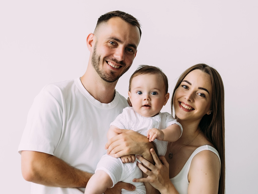 Happy young father mother and cute baby boy family over white background
